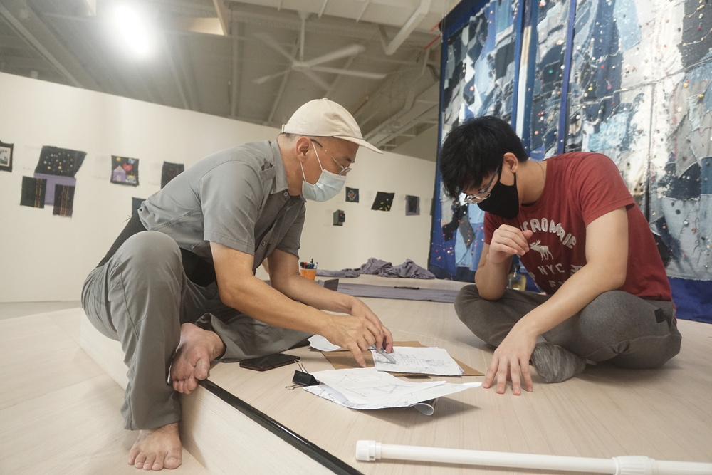 Jimmy Ong having a discussion with a Tzu Ching on the frame and design of the artwork. (Photo by Bernard Ng Jia Han) 