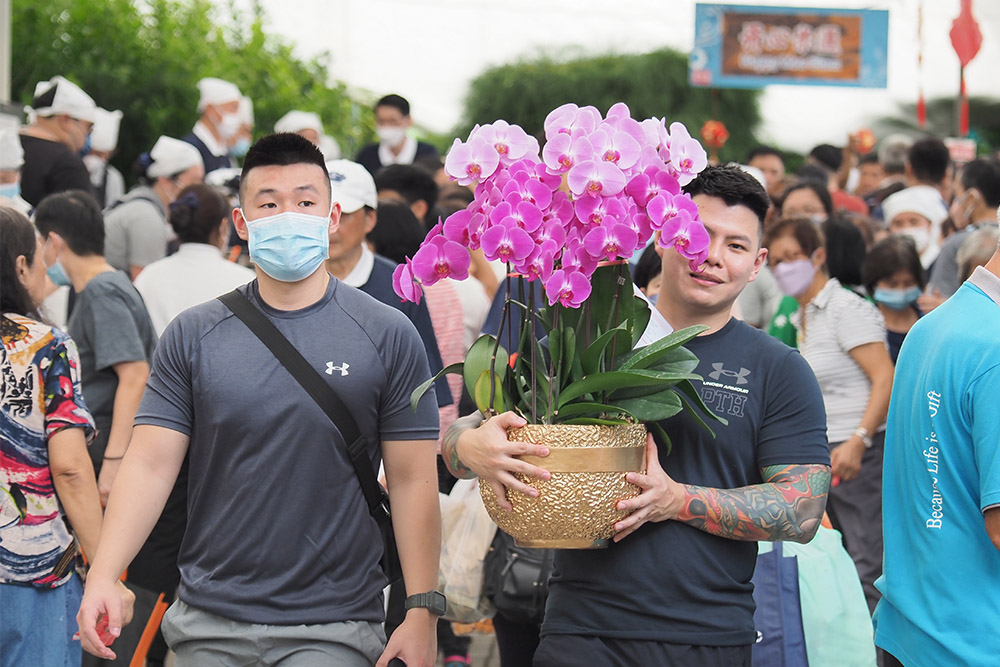 会众抱着雅致的年花，欢喜回家迎新年。（摄/ 洪德谦）