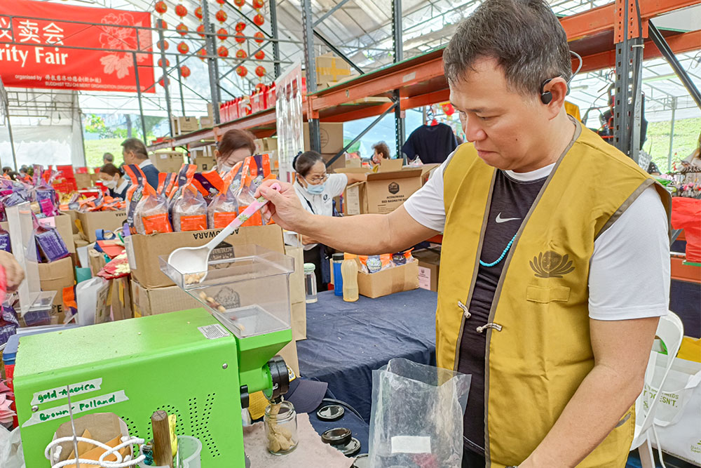 优酱摊主梁祥荣现场演示冷压研磨有机坚果酱，同时介绍多种吃法。（摄/ 黄福顺）